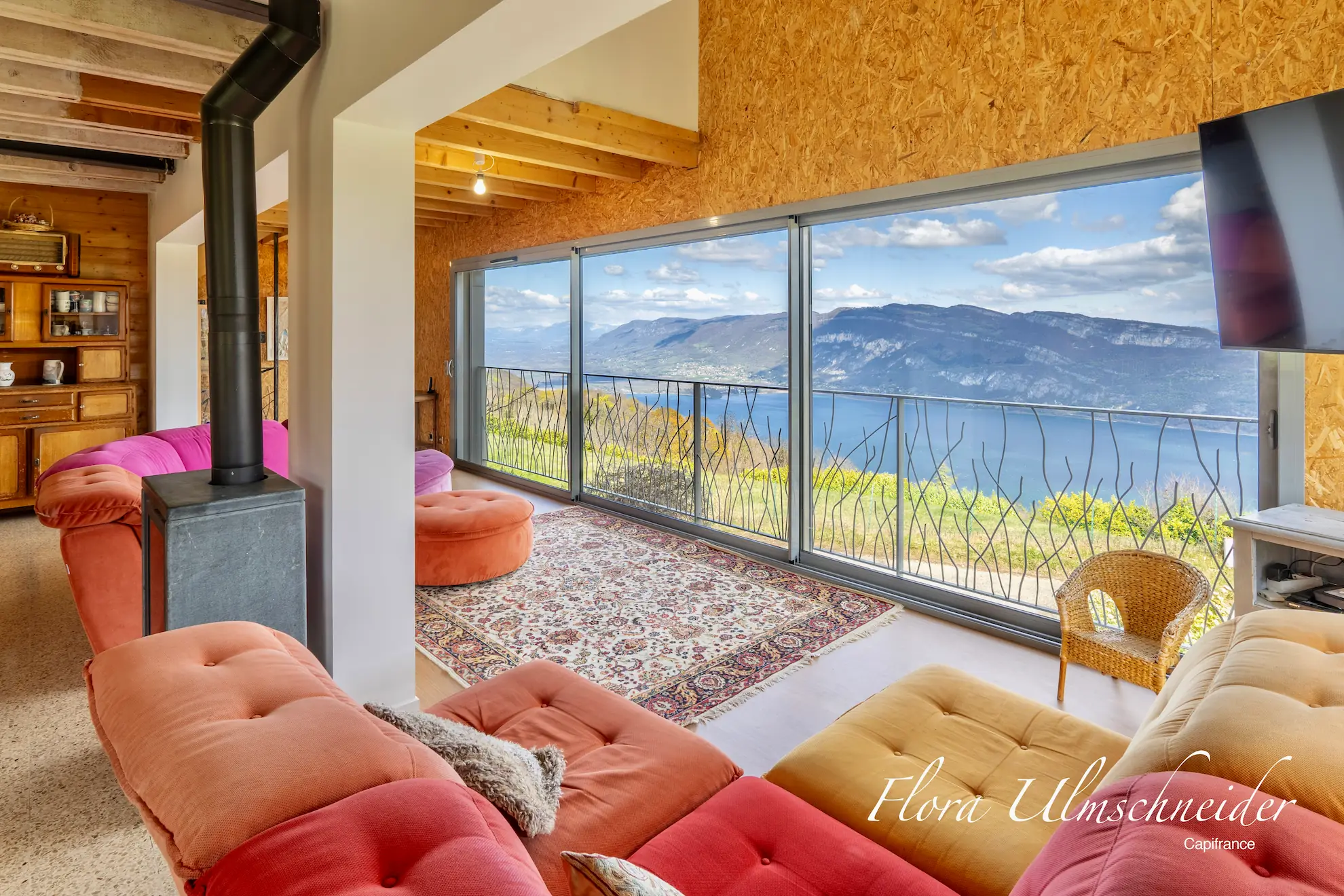 Salon lumineux avec baie vitrée et vue panoramique sur le lac du Bourget - photographie immobilière HDR